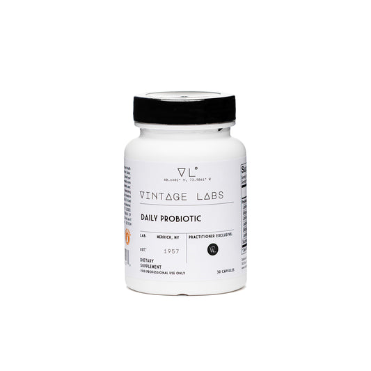 White supplement bottle with black cap labeled 'Vintage Labs Daily Probiotic' on a white background